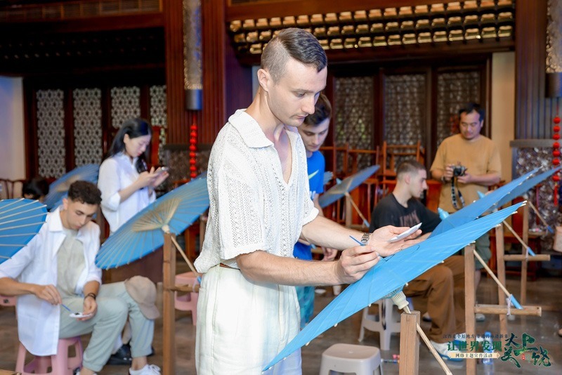 采风团手绘甲路纸伞，体验非遗技艺。