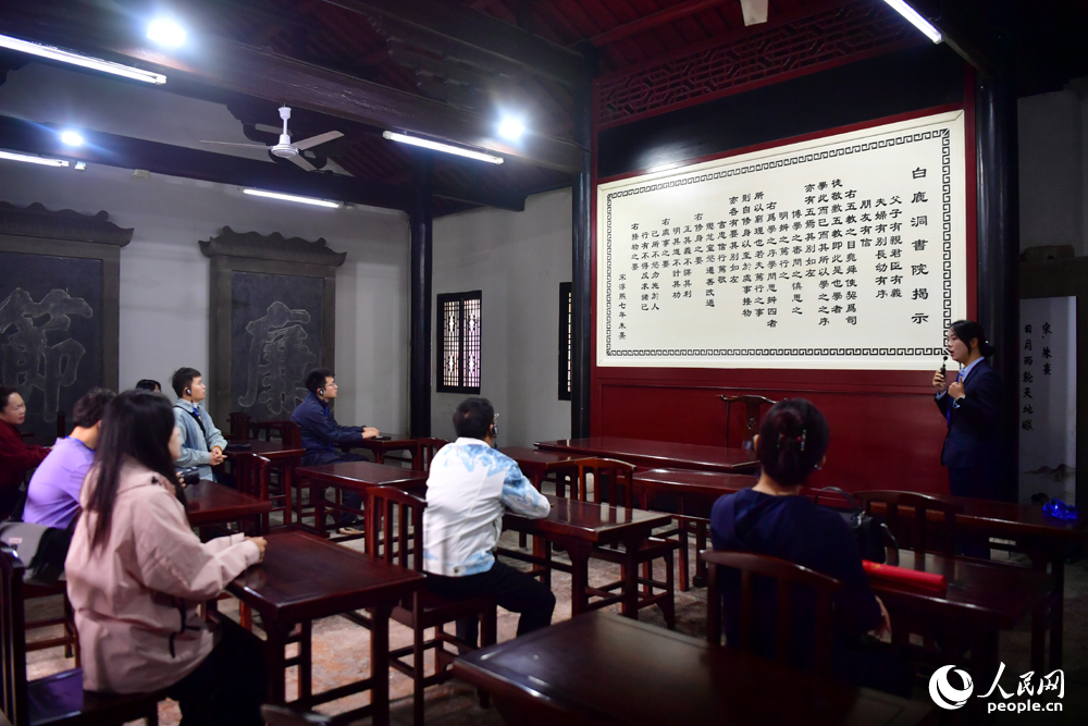“庐山天下悠”网络主题宣传活动调研团成员在《白鹿洞书院揭示》碑刻前听讲解。人民网记者 时雨摄